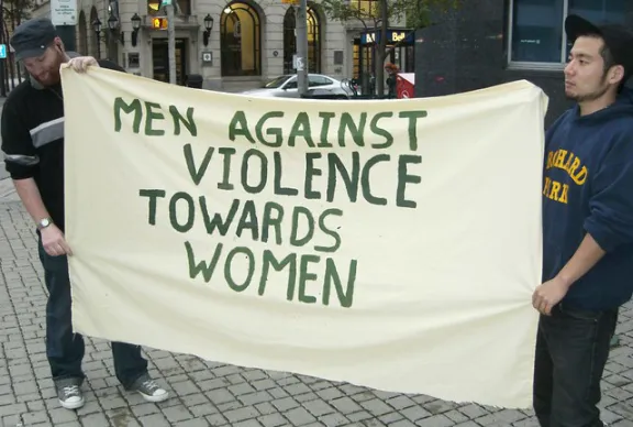 Men holding sign opposing violence against women.