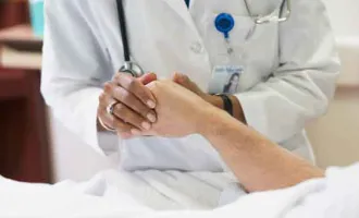 Doctor's hand holding patient's hand