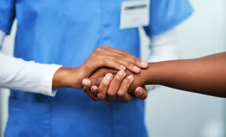 Doctor holding patient hand.