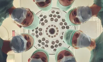 Doctors look down at patient