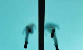 Low angle image of people walking on glass floor.