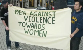 Men holding sign opposing violence against women.
