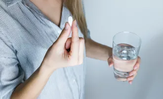 Woman holding a pill.
