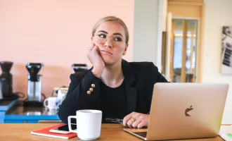 Woman appearing bored at computer.