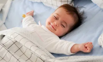 A baby sleeps with a smile on her face.