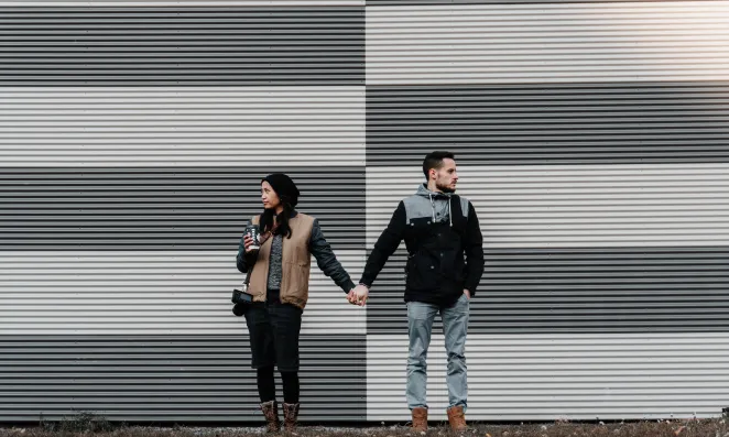 Couple holding hands far apart