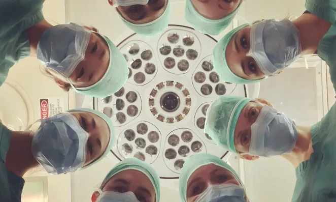 Doctors look down at patient