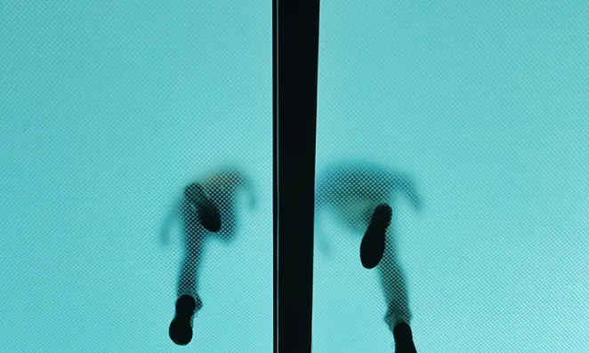 Low angle image of people walking on glass floor.