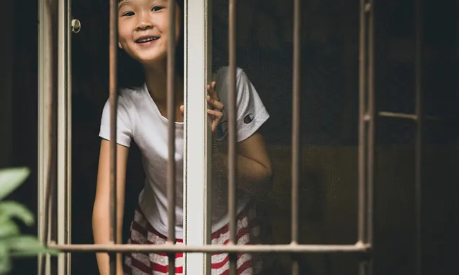 Girl saying high through window.