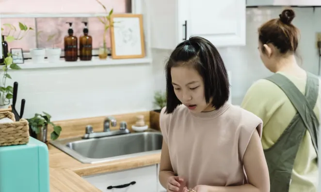 Child helping her mother in the kitchen