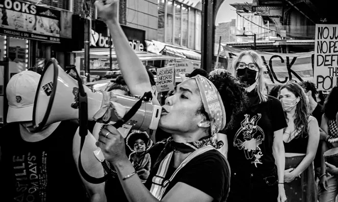 Woman with megaphone and fist in air.