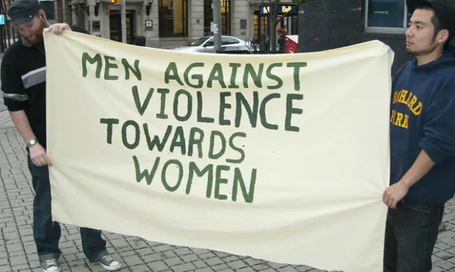 Men holding sign opposing violence against women.