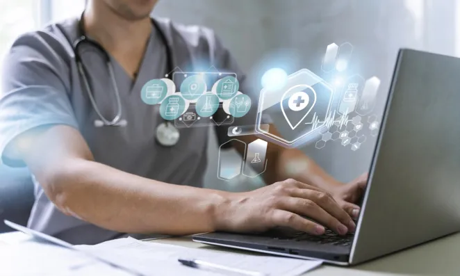 Medical professional working on a laptop.