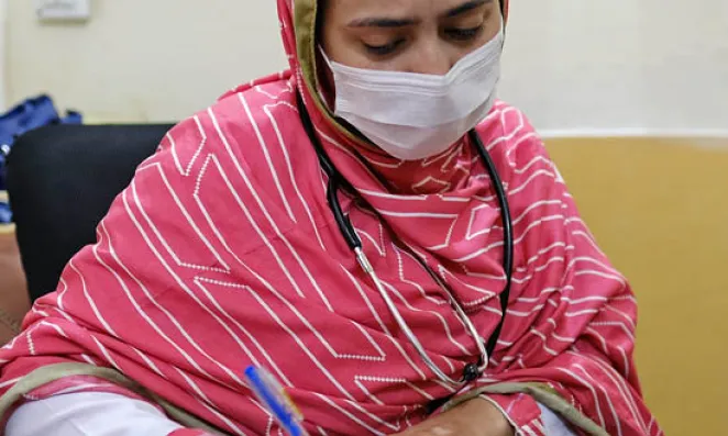 Woman writing on a legal pad.