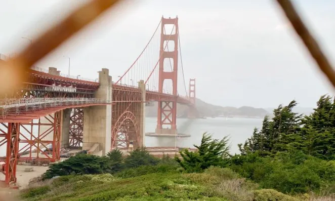 View of Golden Gate Bridge through a fence.