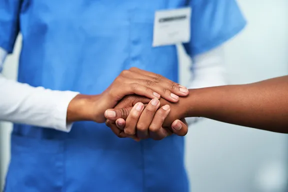 Doctor holding patient hand.