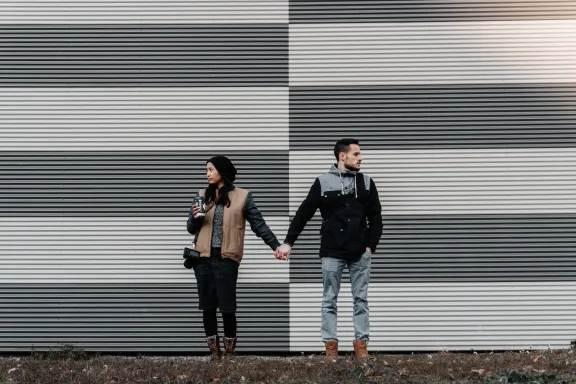 Couple holding hands far apart