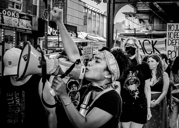 Woman with megaphone and fist in air.