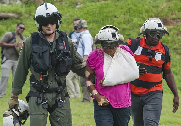 An aircrewman prepares an injured resident for evacuation.