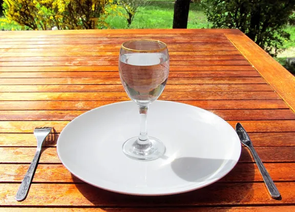 glass of water on an empty plate