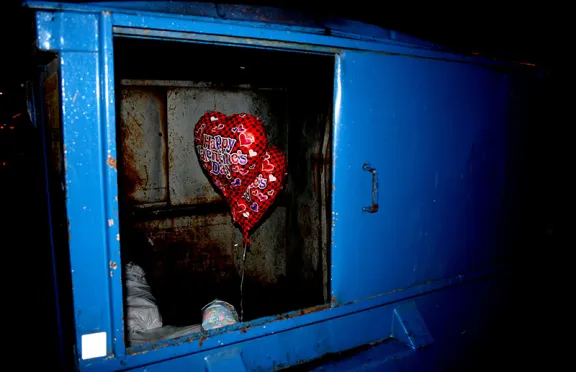 Heart balloons in a dumpster